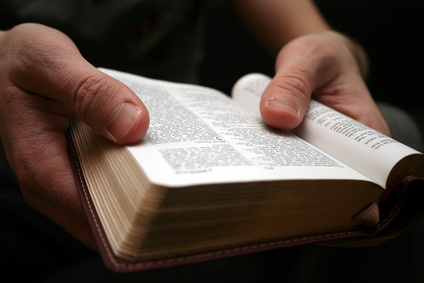 young man reading small bible