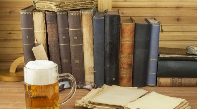 Cool glass of beer on the table. Relax with a good book with a g